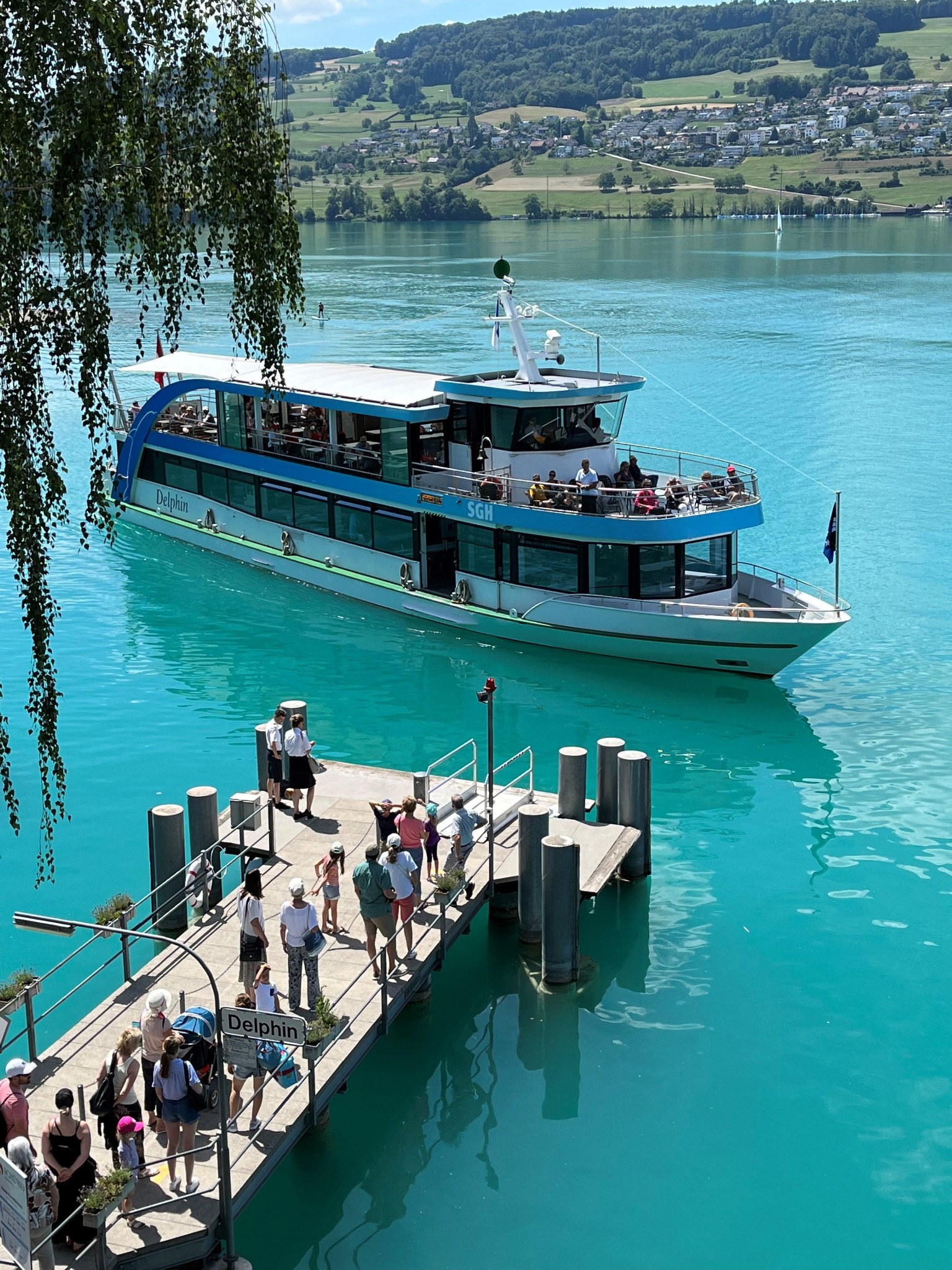 MS Delphin der Schifffahrtsgesellschaft Hallwilersee beim Anlegen mit wartenden Gästen am Steg